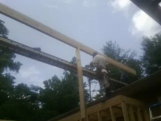 Carpenter setting a ridge beam over a new addition frame — Ice Dam Removal by Roofing Brothers in Lowry City