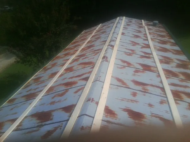 Rusted metal roof panels with new wood purlins before replacement — Storm Damage Roof Repair in Lowry City by Roofing Brothers